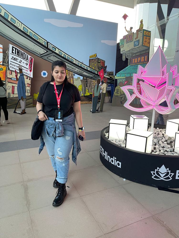Ruhi walking through the ETHIndia 2022 venue with a hacker badge